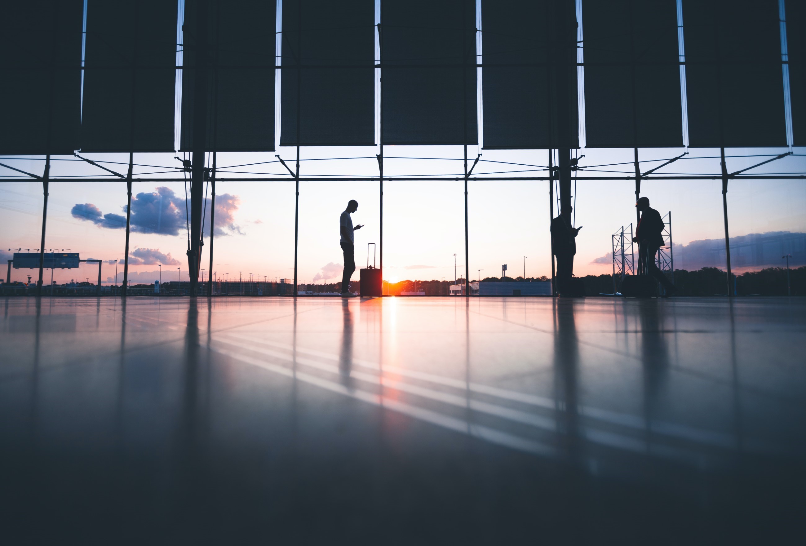 Man Waiting In An Airport Next To His Suitcase