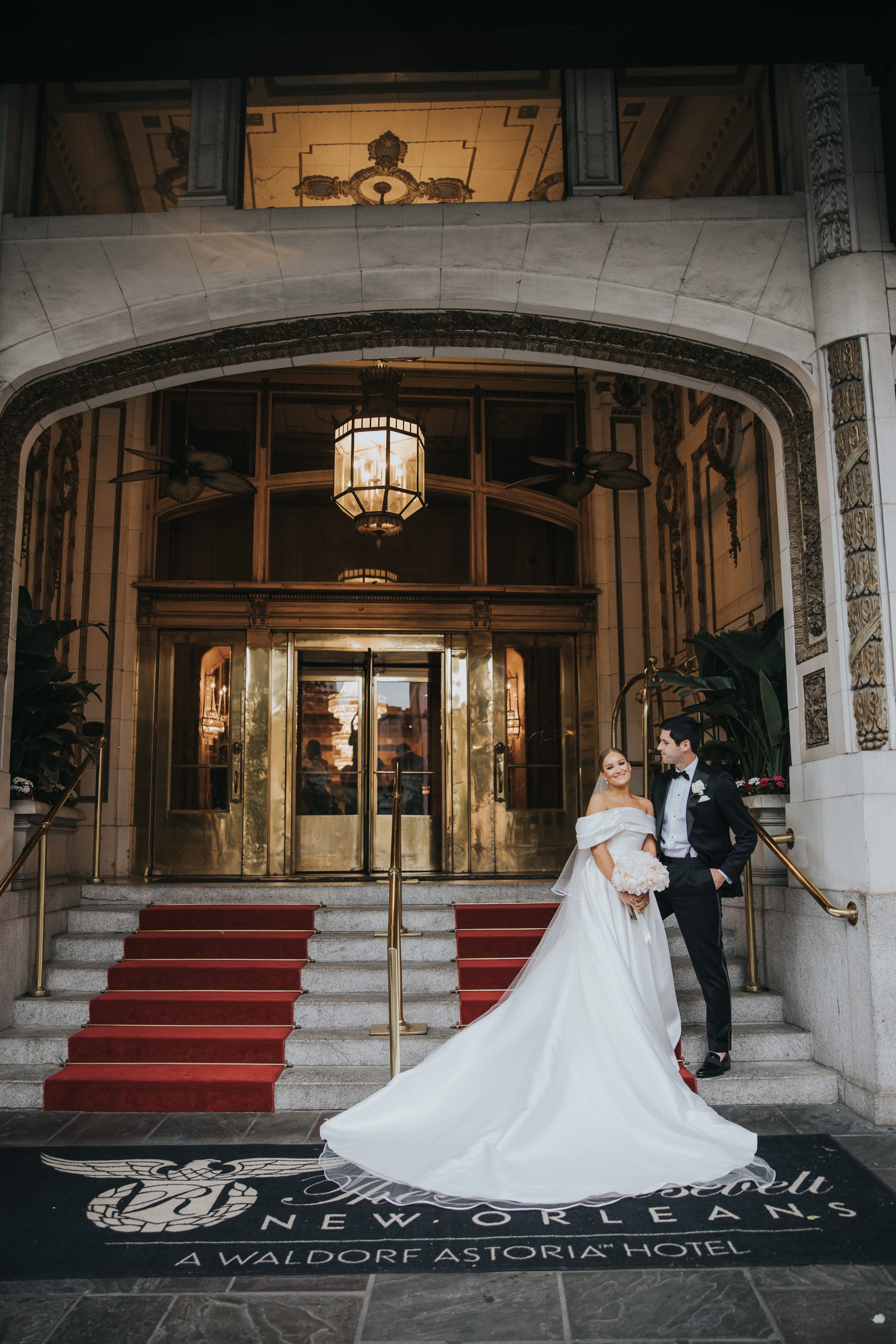 Bride And Groom Standing On The Steps Of The Entrance To The Roosevelt New Orleans